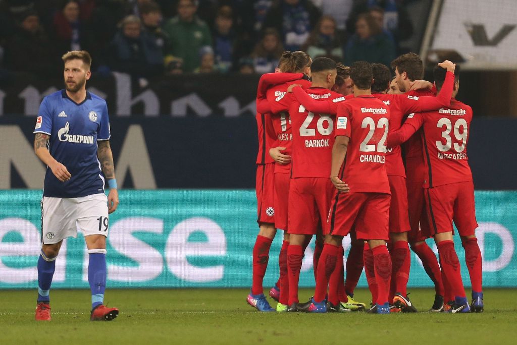 Schalke's Guido Burgstaller walks past celebrating players of Frankfurt during the German First division Bundesliga football match Schalke 04 vs Eintracht Frankfurt in Gelsenkirchen, western Germany, on January 27, 2017. AFP / Ina Fassbender