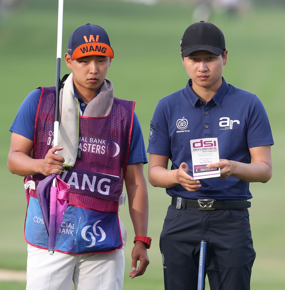 South Korea's Wang Jeunghun (R) competes in the Qatar Masters golf tournament at the Doha Golf Club in Doha on January 28, 2017. (AFP / KARIM JAAFAR)