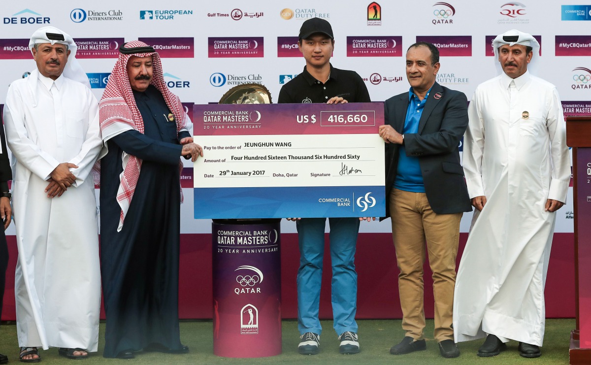 South Korea's Wang Jeungh poses with a cheque bearing his prize after winning the Qatar Masters golf tournament at the Doha Golf Club in Doha on January 29, 2017. (AFP / KARIM JAAFAR)