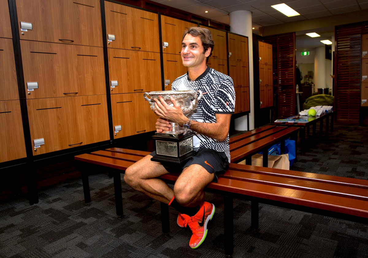 Switzerland's Roger Federer sits with the trophy after winning the Men's singles final at the Australian Open tennis tournament in Melbourne, Australia in this handout image taken January 30, 2017. (Fiona Hamilton/Courtesy of Tennis Australia/Handout via 