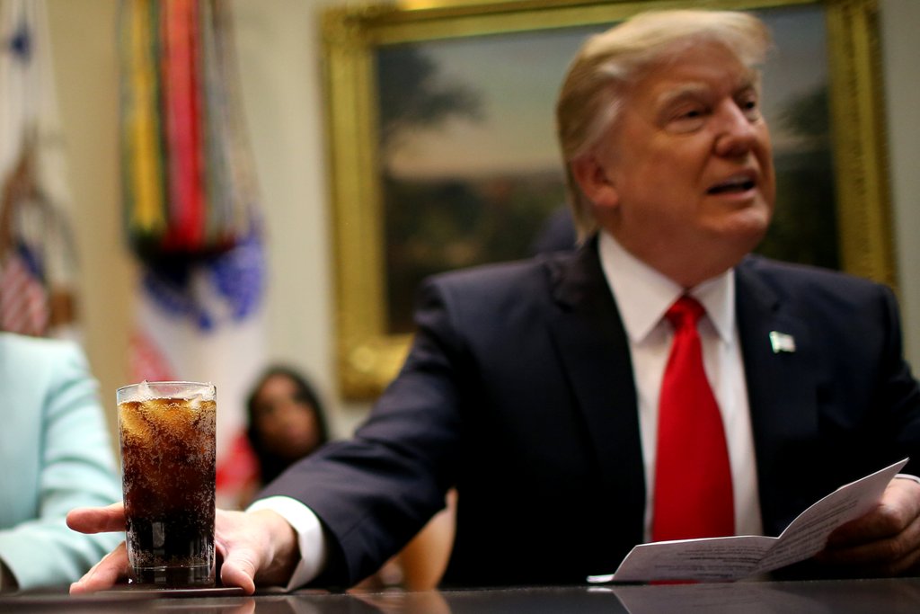 U.S. President Donald Trump holds a beverage as he attends a breakfast meeting with small business leaders hosted by Trump at the Roosevelt room of the White House in Washington U.S., January 30, 2017. REUTERS/Carlos Barria
