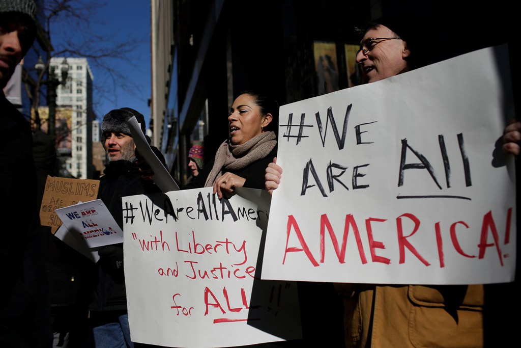 Demonstrators hold up signs during an interfaith solidarity protest against President Donald Trump's executive immigration ban outside the Downtown Islamic Center on February 3, 2017 in Chicago, Illinois. / AFP / Joshua LOTT
