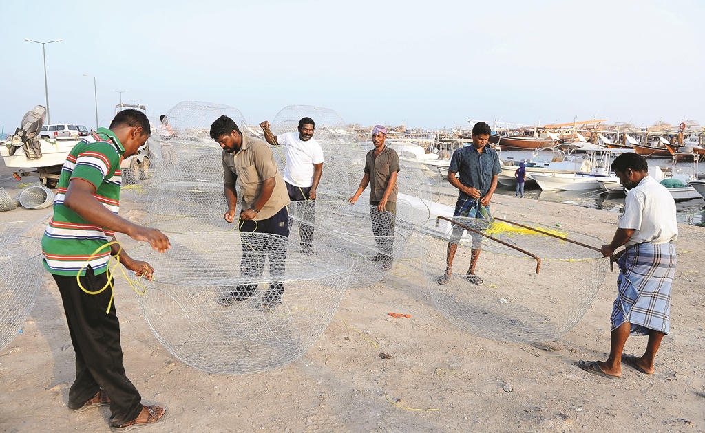 File photo of fishermen fixing ‘Karkur’, a round metal fishing net, at the Al Wakrah fishing port.