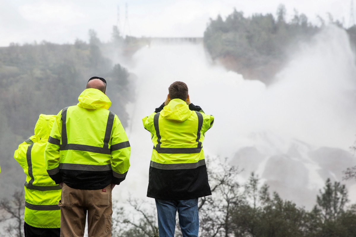 California Department of Water Resources personnel monitor water flowing through a damaged spillway on the Oroville Dam in Oroville, California, U.S., on February 10, 2017. (Reuters)