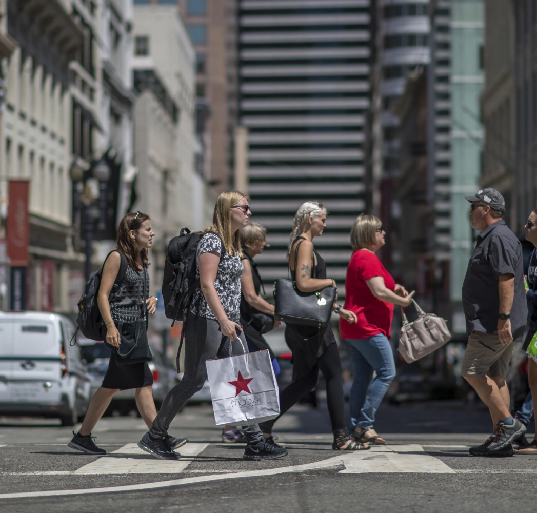 Shoppers carry bags while crossing Post Street in San Francisco. 