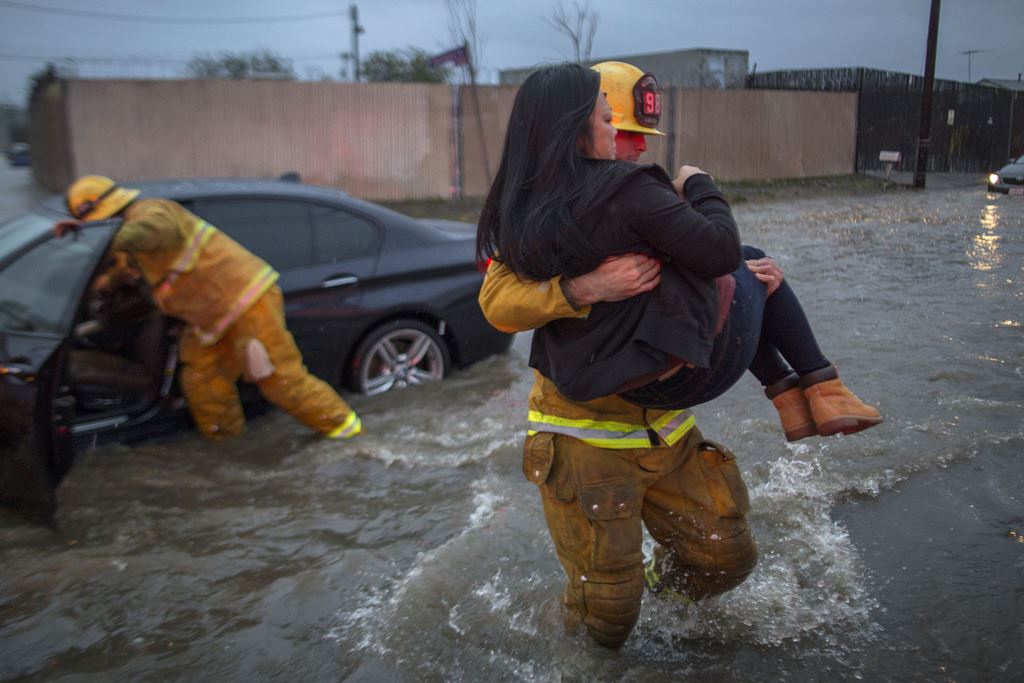 SUN VALLEY, CA:  A firefighter carries a woman from her car after it was caught in street flooding as a powerful storm moves across Southern California on February 17, 2017 in Sun Valley, California. David McNew/Getty Images/AFP