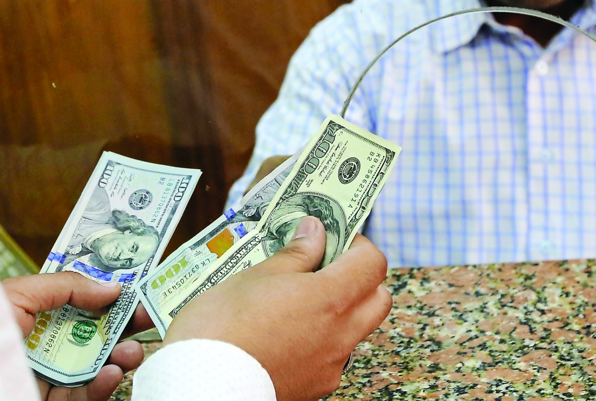 In this file photo, a customer exchanges US dollars to Egyptian pounds in a foreign exchange office in central Cairo.