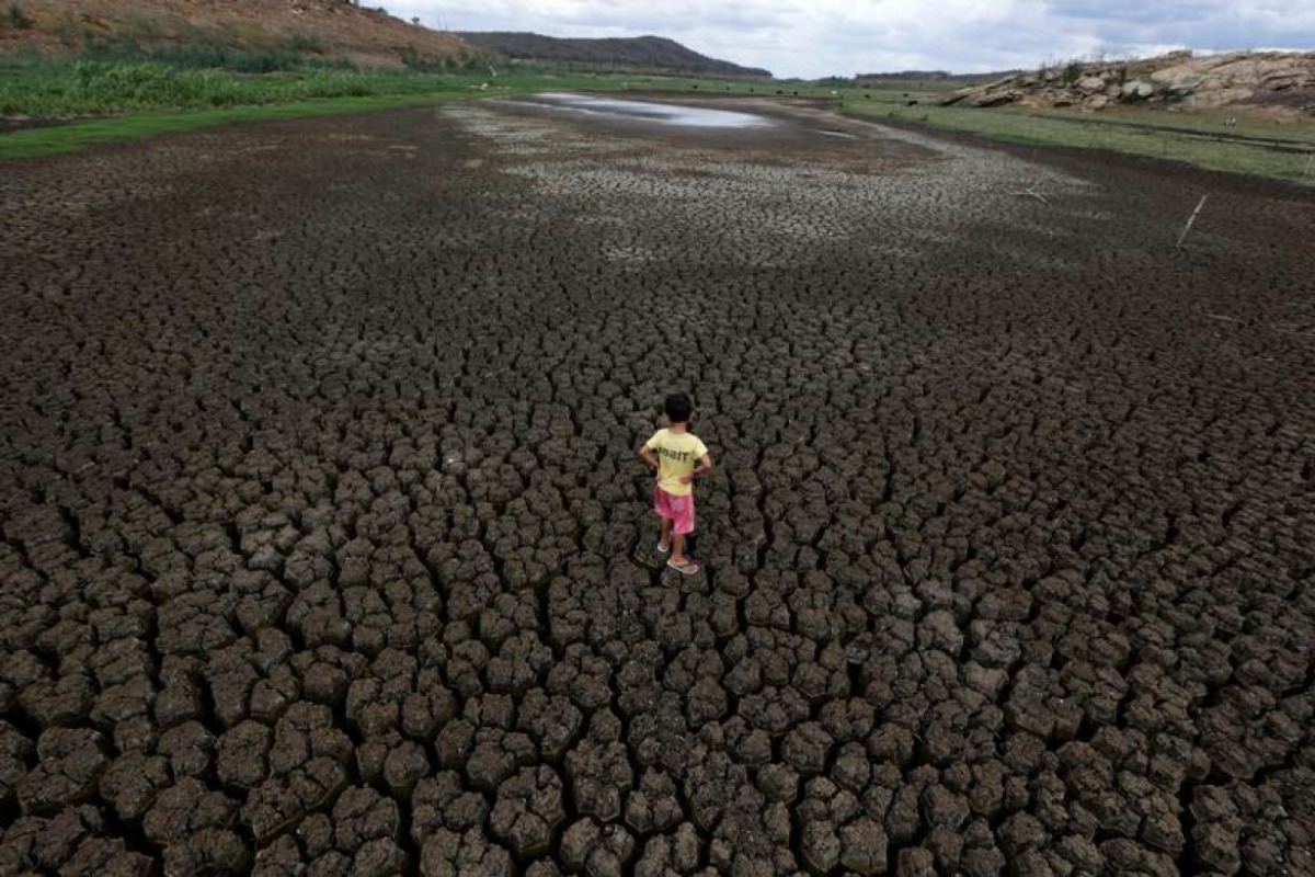 Natan Cabral, 5, stands on the cracked ground of the Boqueirao reservoir in the Metropolitan Region of Campina Grande, Paraiba state, Brazil, February 13, 2017. REUTERS/Ueslei Marcelino
