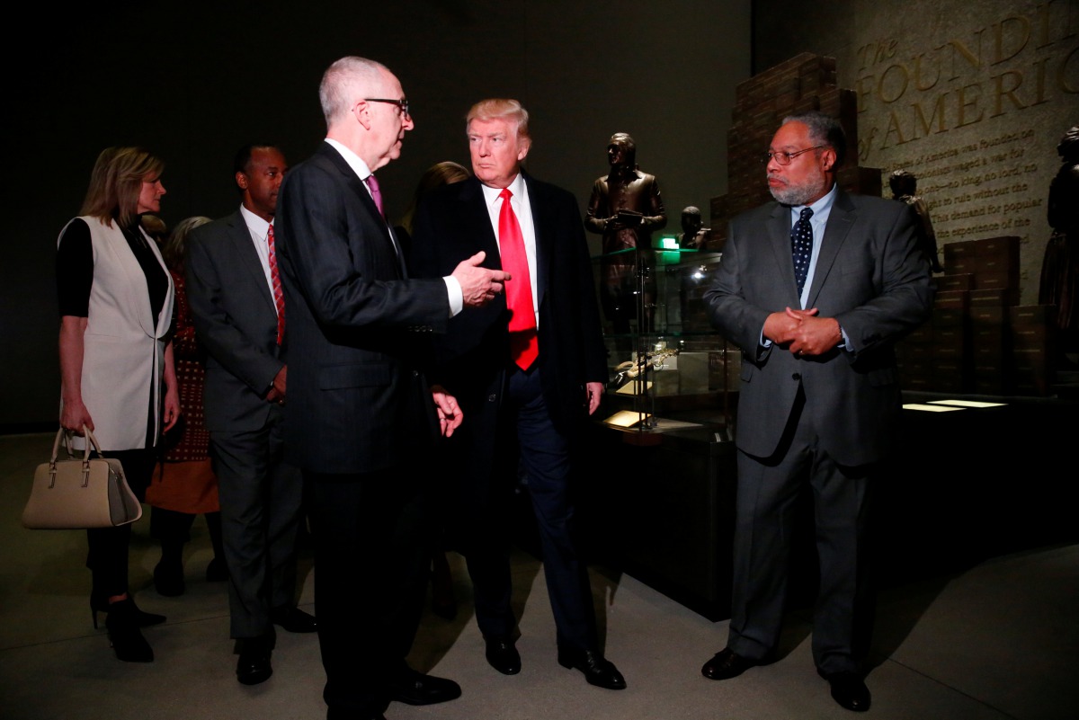 U.S. President Donald Trump (C) views an exhibit on slavery during the American revolution while visiting the National Museum of African American History and Culture in Washington, U.S., February 21, 2017. REUTERS/Jonathan Ernst