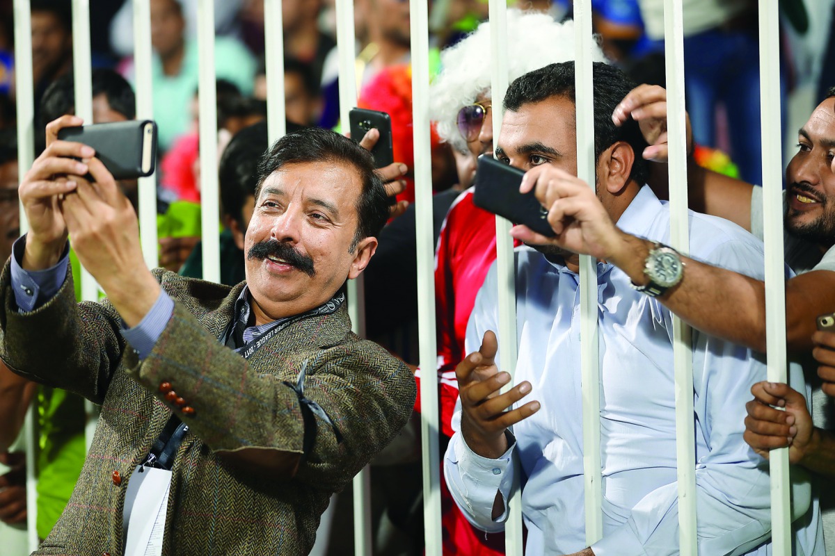 Lahore Qalandars' Qatar-based owner Fawad Rana (left) takes a selfie along with fans during  a PSL match
