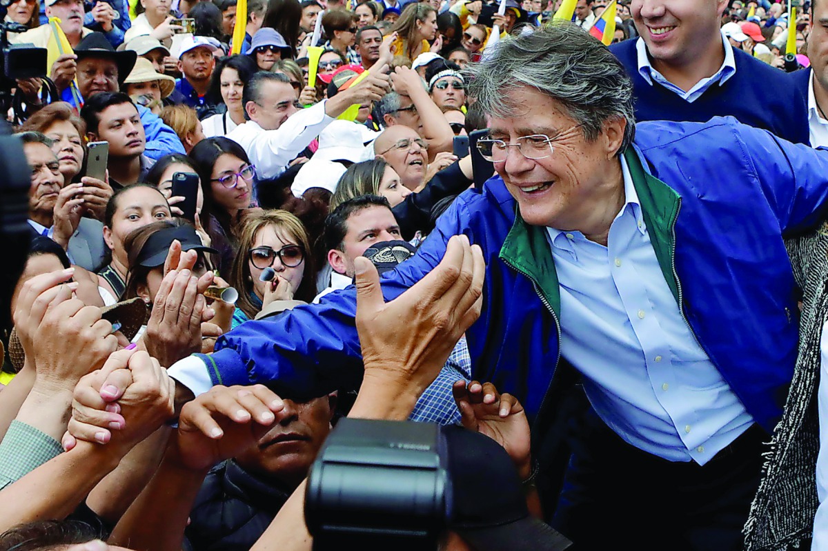 Supporters of Guillermo Lasso, presidential candidate from the CREO party, and other opposition supporters stand outside the electoral council (CNE) headquarters, in Quito, Ecuador. 