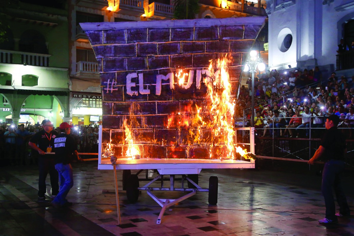 People burn a fake wall in a protest against US President Donald Trump during the inauguration of the carnival festival in Veracruz, Veracruz State, yesterday.