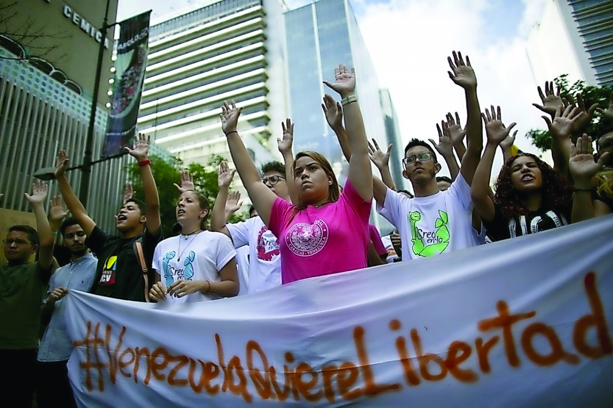 Students holding an anti-government protest to mark the third anniversary since the killing of student protester Bassil da Costa by security forces during weeks of unrest in Caracas.