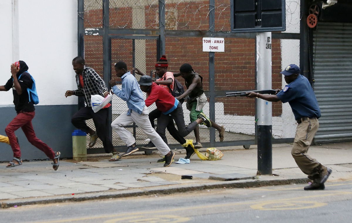 A South African riot policeman fires rubber bullets to disperse South African nationals during a protest march against illegal immigrants in Pretoria, South Africa, yesterday.
