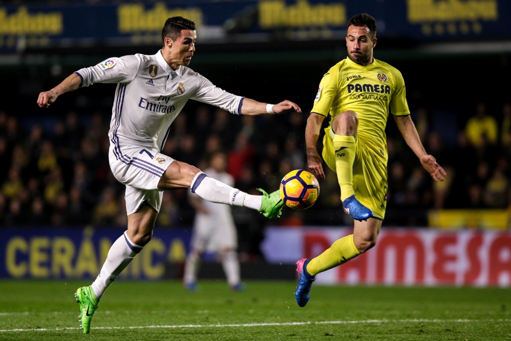 Real Madrid's Portuguese forward, Cristiano Ronaldo (L) vies with Villareal's defender Mario Gaspar during the Spanish League football match Villarreal CF vs Real Madrid at El Madrigal stadium in Vila-real on February 26, 2017. / AFP / BIEL ALINO
