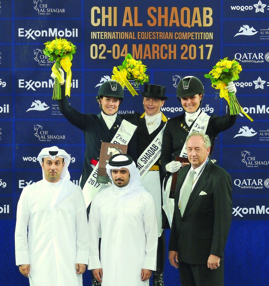 The podium winners of the CDI5* GP FS - Grand Prix Freestyle to Music (GP FS) dressage event of CHI Al Shaqab, Isabell Werth, Cathrine Dufour and Anna Kasprzak pose for a photograph with officials after the presentation ceremony at the Al Shaqab Arena yes