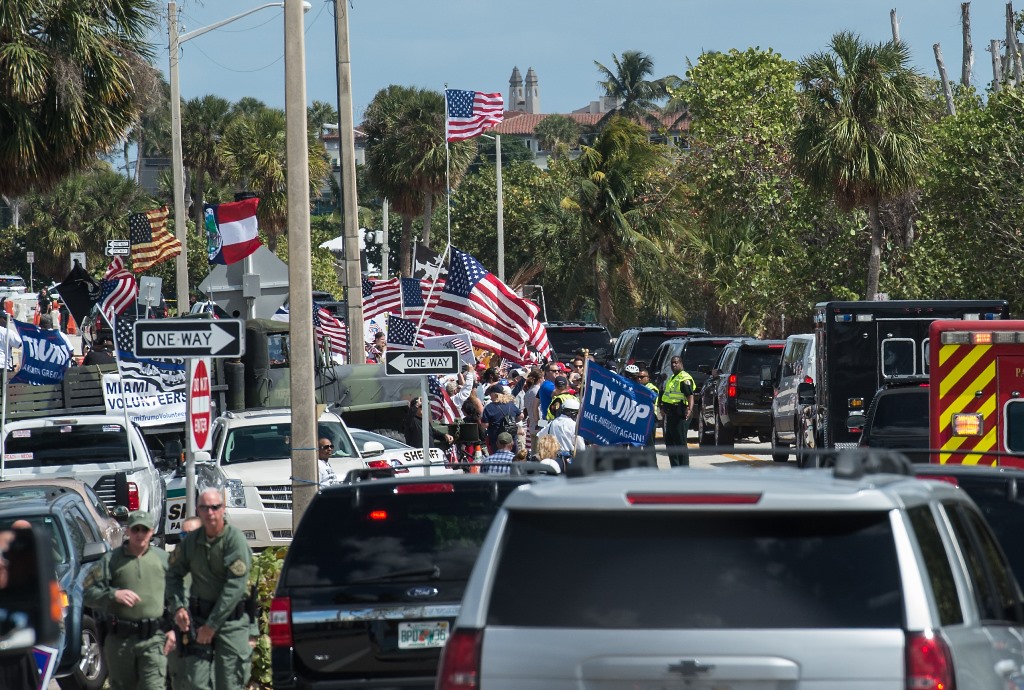 The motorcade of US President Donald Trump stops near supporters standing close to his Mar-a-Lago resort in Palm Beach, Florida, on March 4, 2017. AFP / NICHOLAS KAMM 