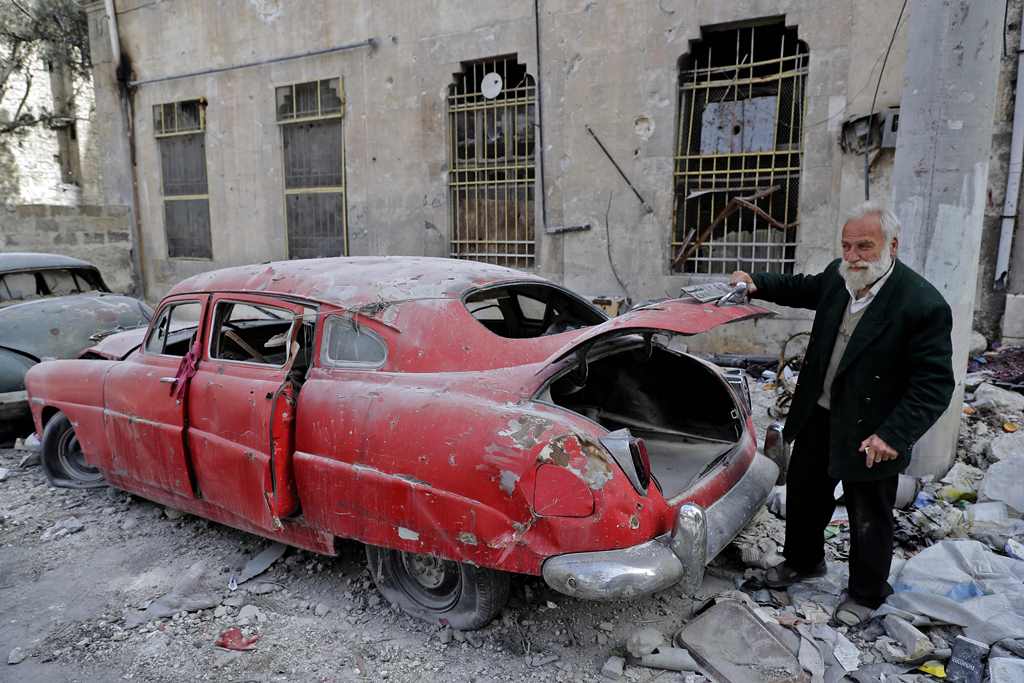 A picture taken on March 9, 2017, shows 70-year-old Mohammad Mohiedine Anis opening the trunk of his 1949 Hudson Commodor outside his home in Aleppo's formerly rebel-held al-Shaar neighbourhood. AFP / JOSEPH EID