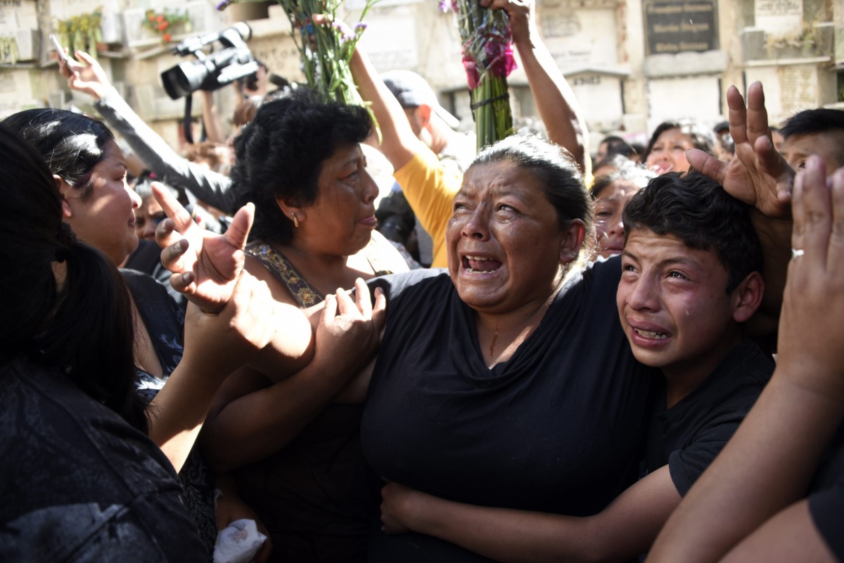Relatives and friends cry at the funeral of 14-year-old Madelyn Patricia Hernandez Hernandez, who died in a fire at a state-run shelter, at the general cemetery in Guatemala City on March 10, 2017. AFP / Johan Ordonez