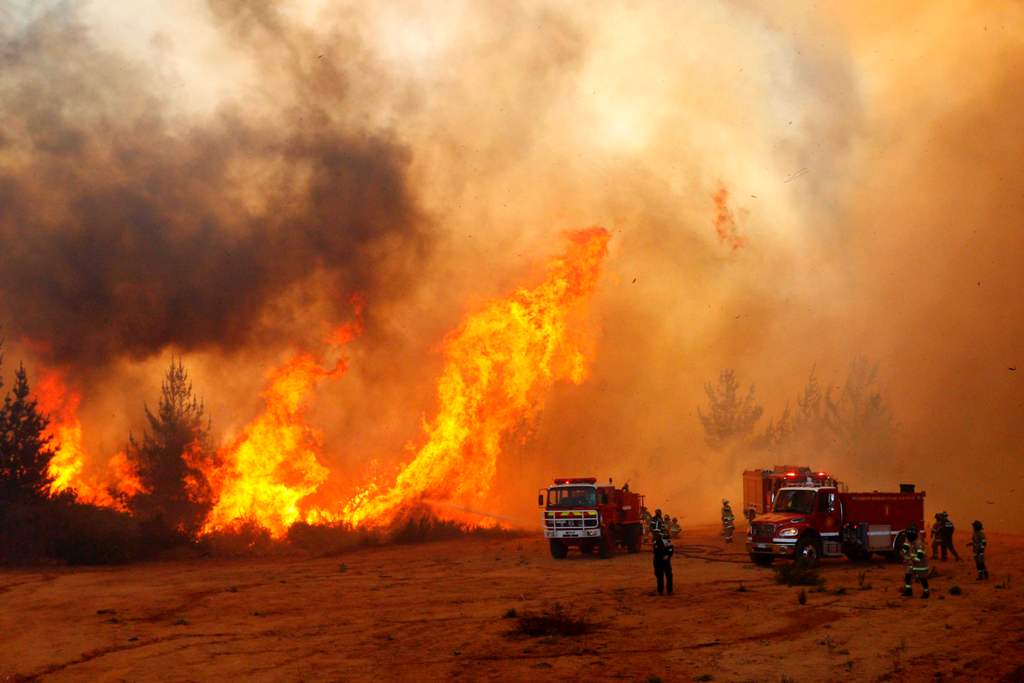 Picture released on March 12, 2017 by Aton Chile shows firefighters working to put out a forest fire in Valparaiso.  AFP / Raul ZAMORA 