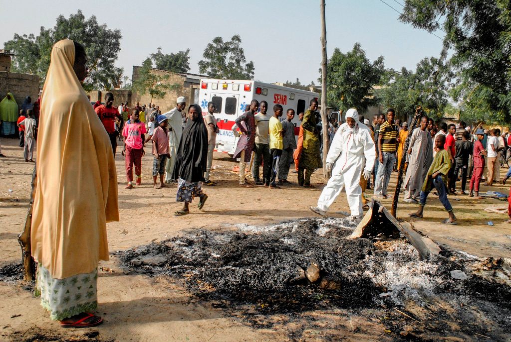 A Muslim woman looks on while standing near the site where four female suicide bombers blew themselves up near a bus station in Maiduguri, northeastern Nigeria on March 15, 2017 killing two people, the country's disaster agency said. AFP / STRINGER