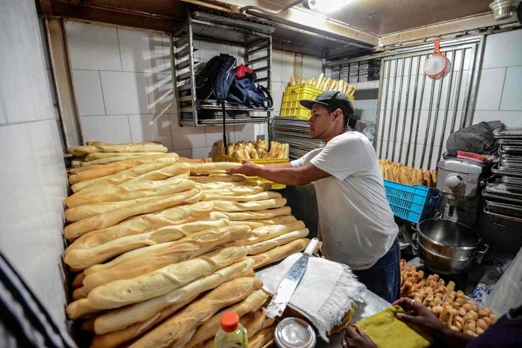 Members of a pro-government community organisation work in an expropriated bakery in Caracas on March, 17, 2017.  AFP / JUAN BARRETO
