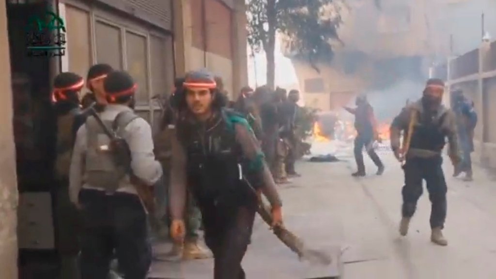 A still image taken from a video uploaded on social media on March 20, 2017, shows fighters, said to be members of Ahrar Al Sham group, walking near burning tyres, said to be in Damascus, Syria. Social Media Website via Reuters 