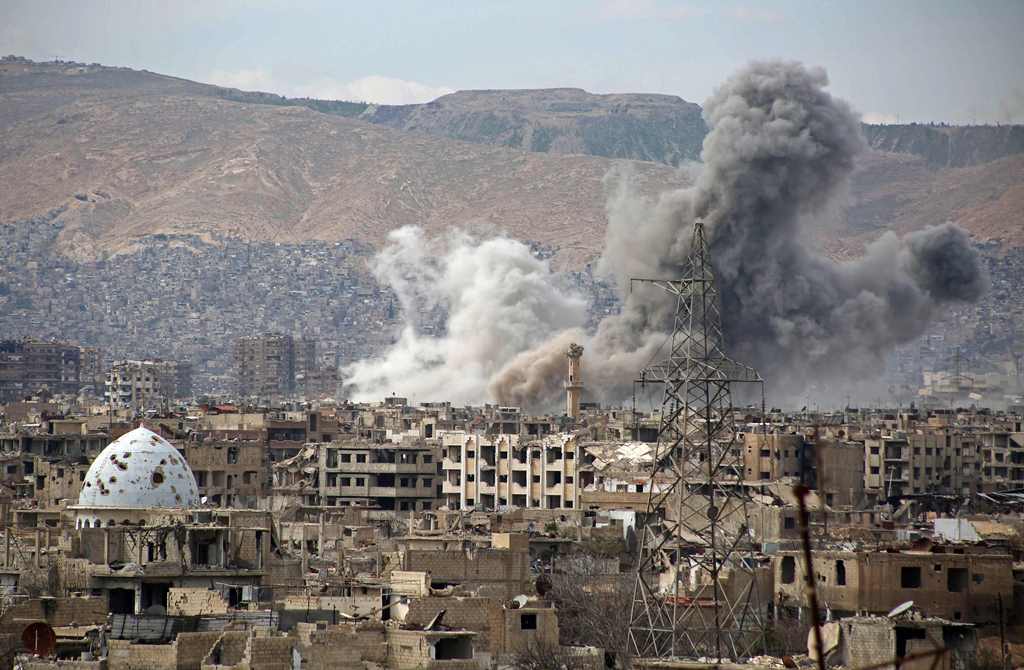 A general view show smoke rising from buildings following an air strike on Jobar, a rebel-held district on the eastern outskirts of the Syrian capital Damascus, on March 21, 2017. AFP / Ammar SULEIMAN