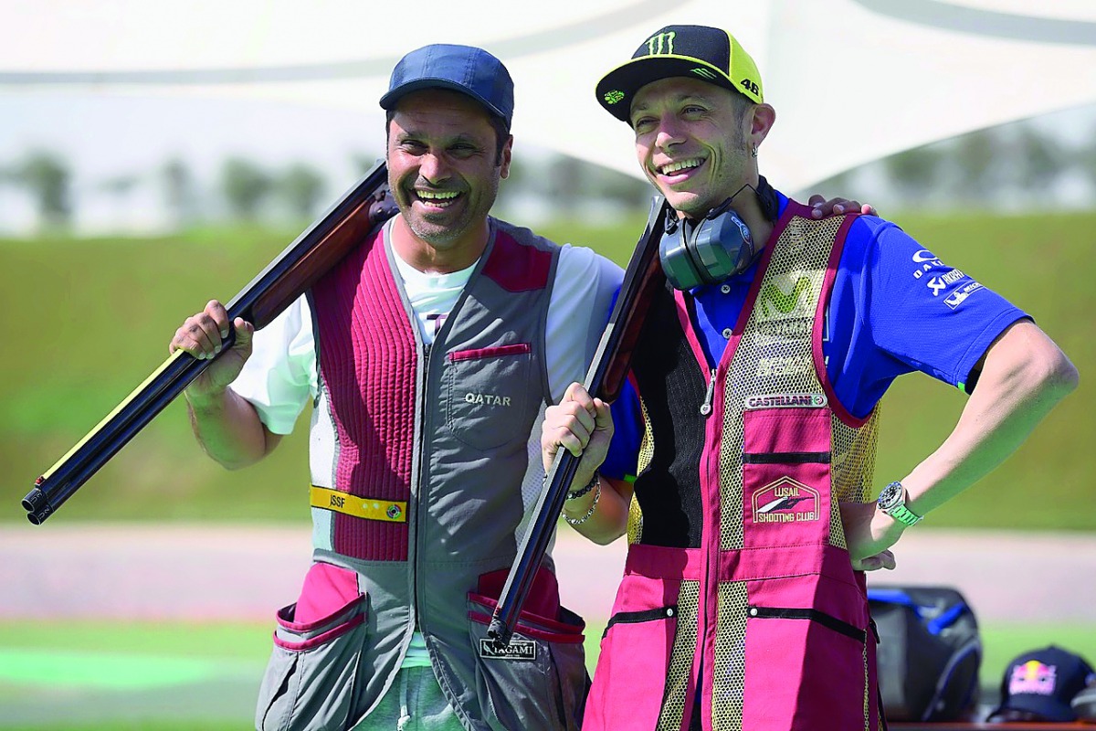 Movistar Yamaha MotoGP rider Valentino Rossi and Qatar's multi-talented hero Nasser Saleh Al Attiyah pose for a photograph following a shooting session at Losail yesterday. 