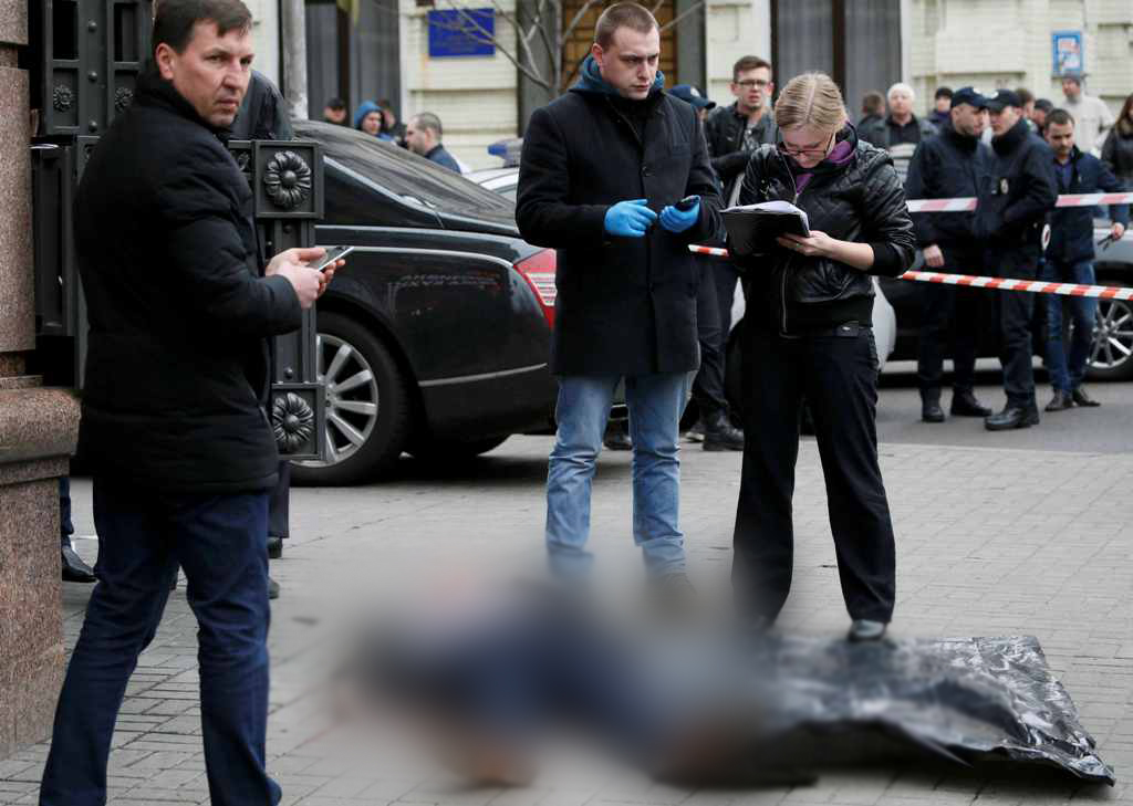 Investigators inspect the body of Denis Voronenkov, a former lawmaker of the Russian State Duma, who was shot dead, in central Kiev, Ukraine March 23, 2017. REUTERS/Valentyn Ogirenko 
