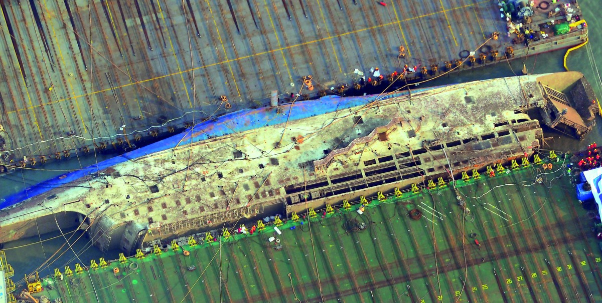 Part of the damaged Sewol ferry between two barges after being raised during a salvage operation at sea off the southwestern island of Jindo, yesterday.