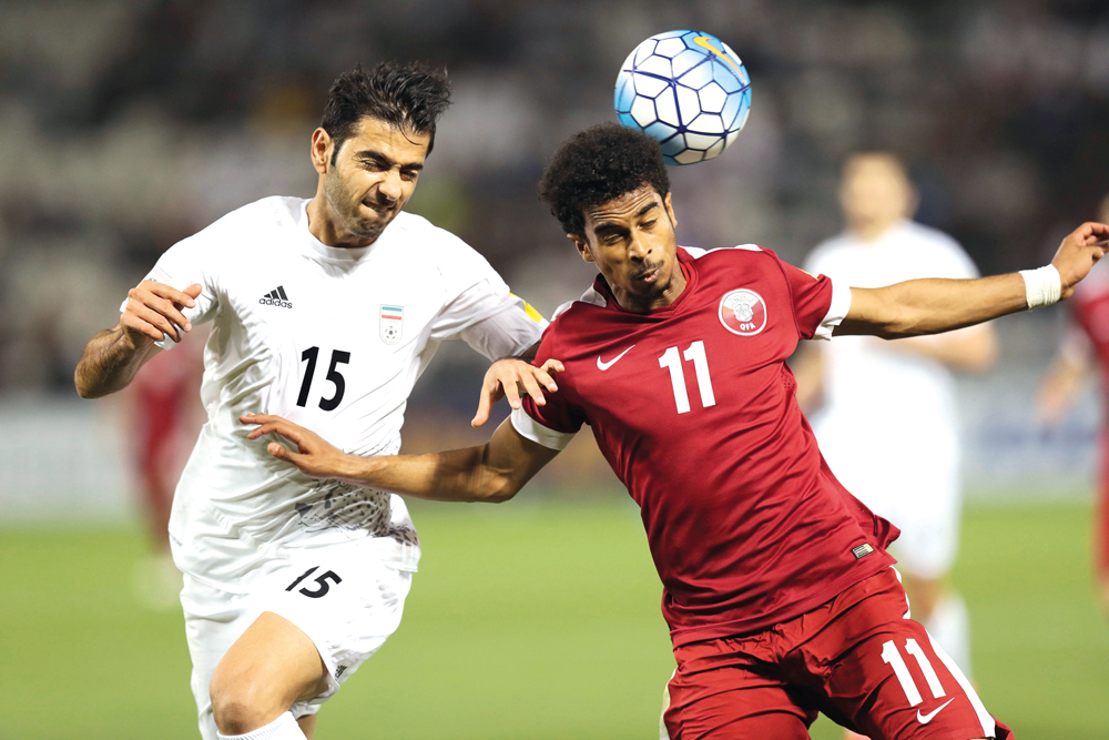 Qatar's Akram Hassan Afif (right) in action with Iran's Pejman Montazeri during the World Cup 2018 Asia qualifying football match at the Jassim Bin Hamad stadium in Doha on Thursday.