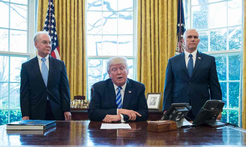US President Donald Trump, with Vice President Mike Pence (R) and Health and Human Services Secretary Tom Price (L), pauses as he speaks from the Oval Office of the White House in Washington, DC, on March 24, 2017. AFP / MANDEL NGAN