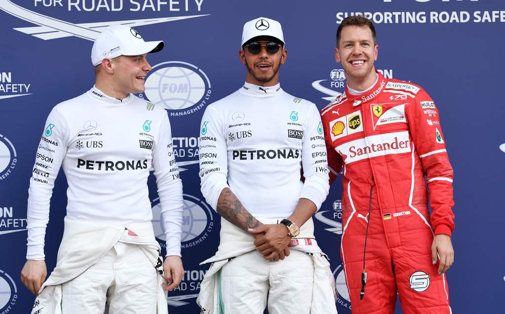 Mercedes' British driver Lewis Hamilton (C), teammate Mercedes' Finnish driver Valtteri Bottas (L) and Ferrari's German driver Sebastian Vettel (R) chat after the qualifying session at the Formula One Australian Grand Prix in Melbourne on March 25, 2017. 