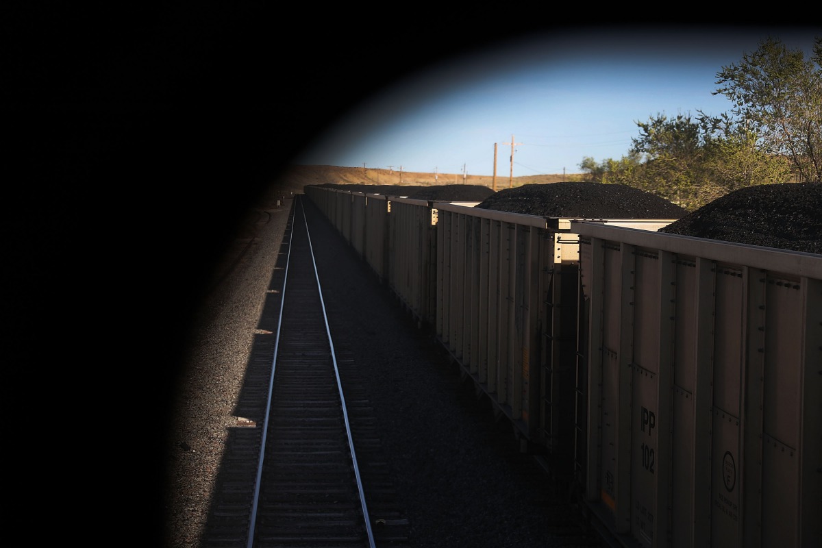 FILE PHOTO: Train cars loaded with coal pass California Zephyr as it rolls along the tracks during its daily 2438-mile trip to Emeryville, San Francisco from Chicago (Joe Raedle / Getty Images / AFP) 