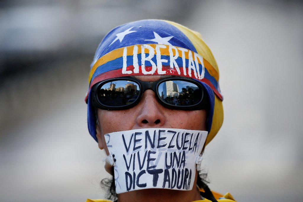 An opposition supporter with a sign that reads, 