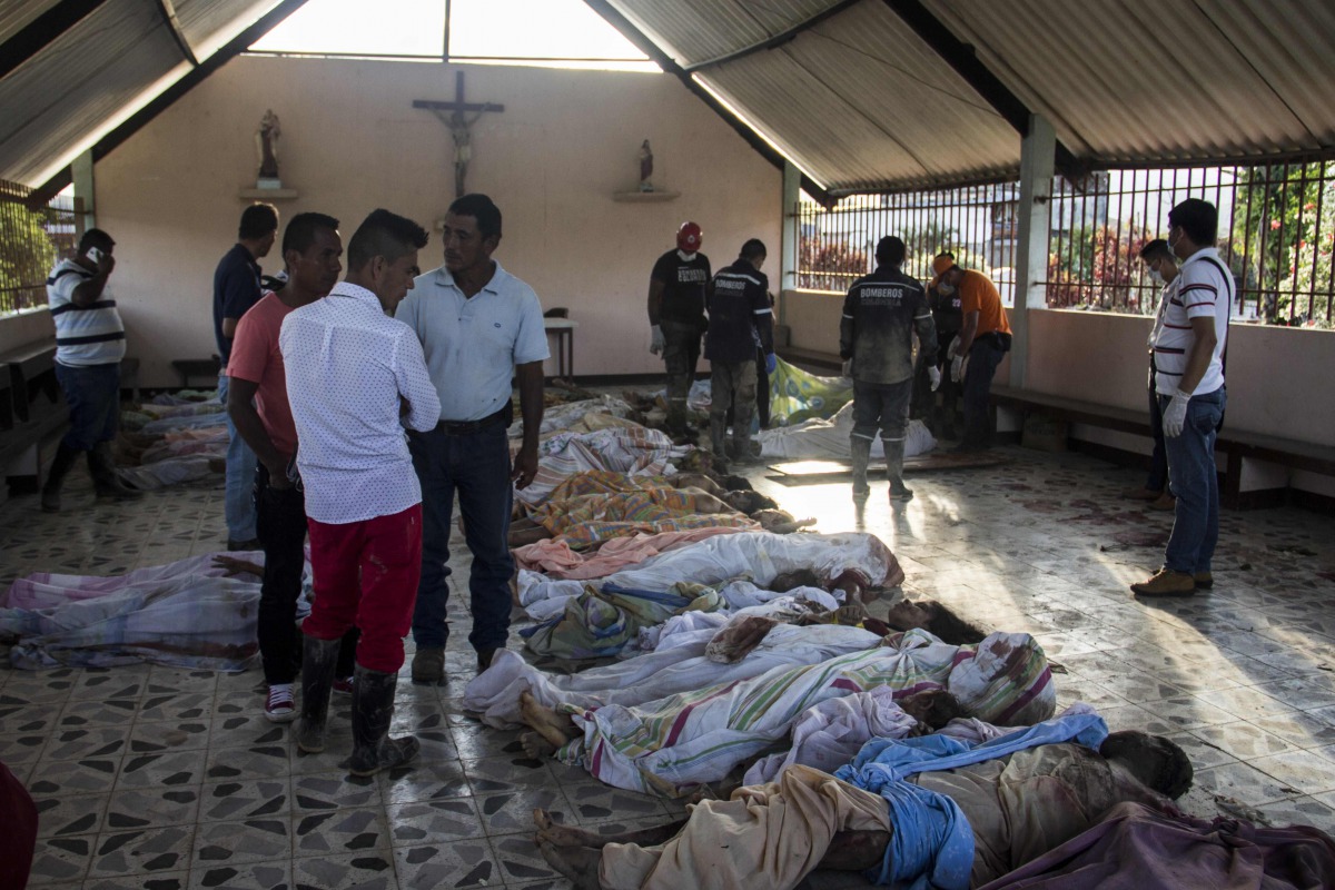 People look for family members among the bodies of victims of mudslides following heavy rains, at the cemetery in Villagarzon, Putumayo department, southern Colombia on April 1, 2017. A massive mudslide left more than 200 dead and hundreds of injured and 