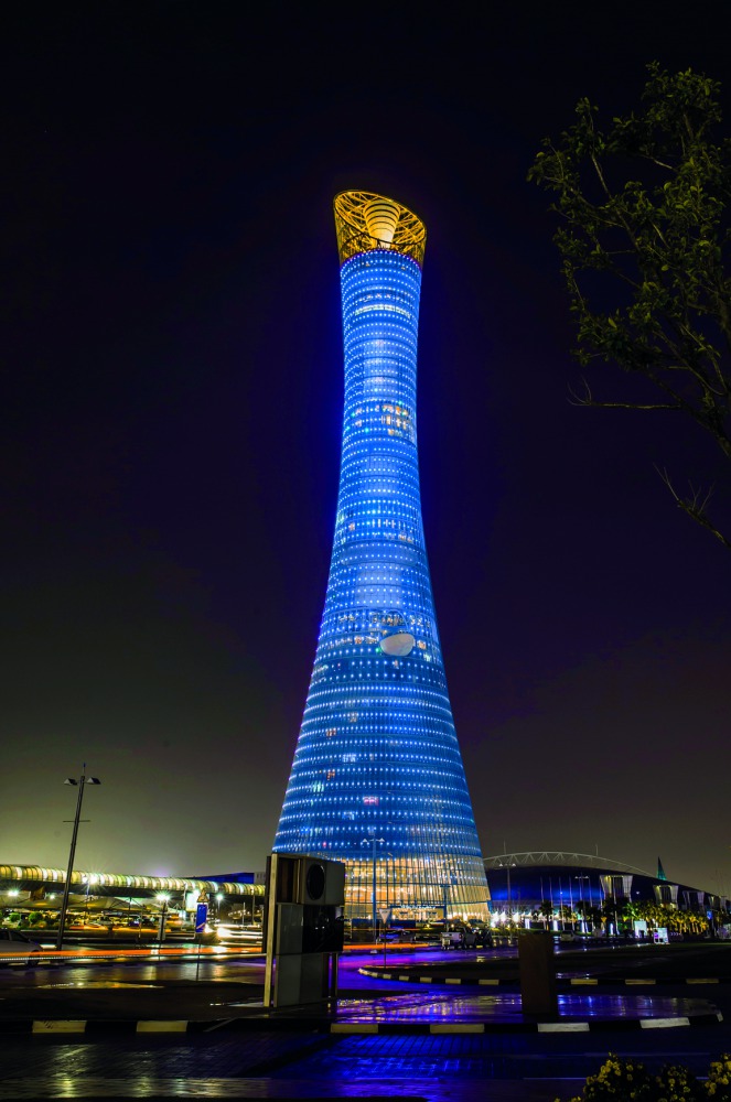 The Torch Doha illuminated in blue.