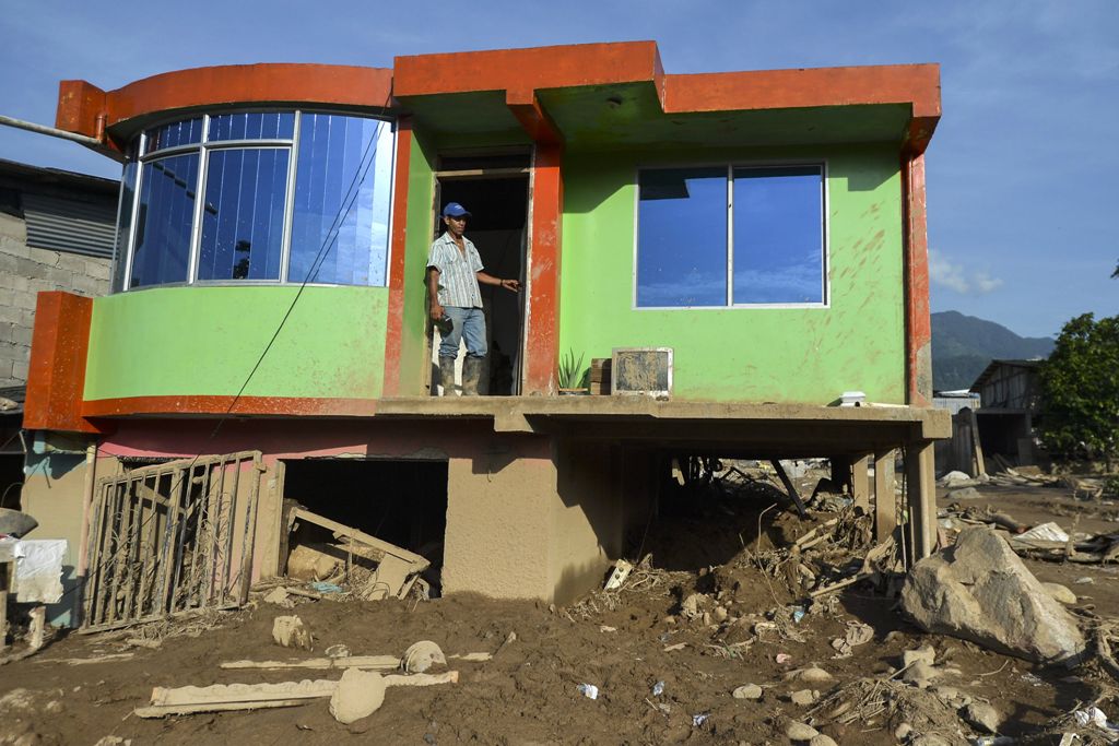 A man stands in the doorway of his house, which was damaged by a mudslide caused by heavy rains in Mocoa, Putumayo department, Colombia on April 5, 2017.  AFP / LUIS ROBAYO
