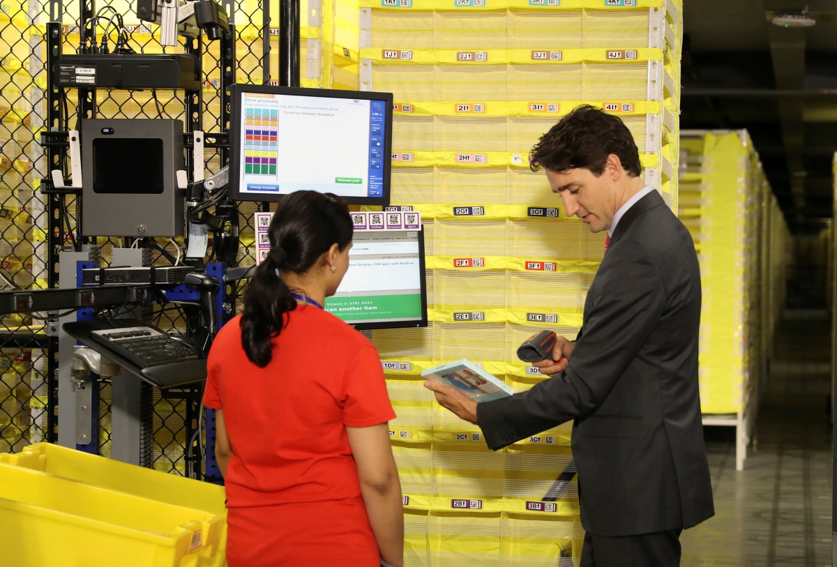 Canada Prime Minister Justin Trudeau scans merchandise with an employee during a tour of the Amazon Fulfillment Centre in Brampton, Ontario, Canada, October 20, 2016 (REUTERS / Fred Thornhill) 