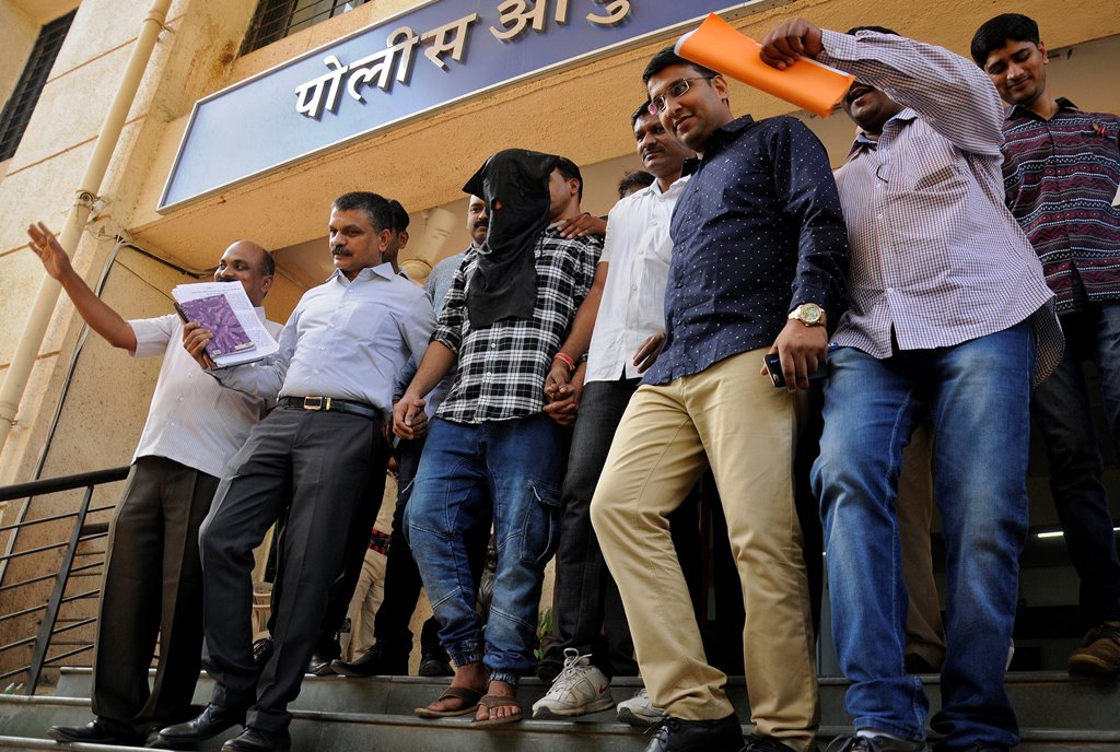Police officials escort Sagar Thakkar, the suspected mastermind in the Internal Revenue Service (IRS) call center scams, to a police station in Thane, on the outskirts of Mumbai, India, April 8, 2017. REUTERS/Stringer 