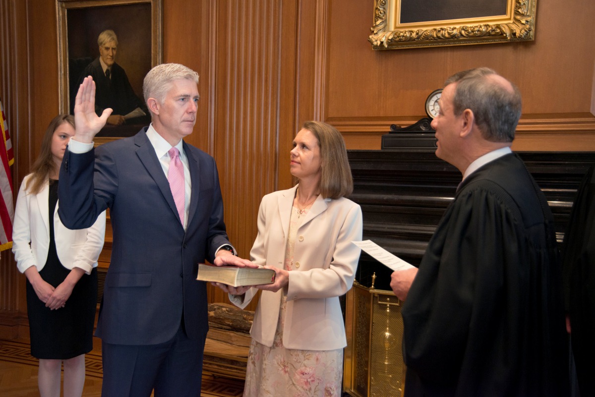 Chief Justice of the United States John Roberts (R) administers the constitutional oath to judge Neil Gorsuch, as his wife Louise Gorsuch holds the bible during a private ceremony at the Supreme Court in Washington, U.S., April 10, 2017. Courtesy Supreme 