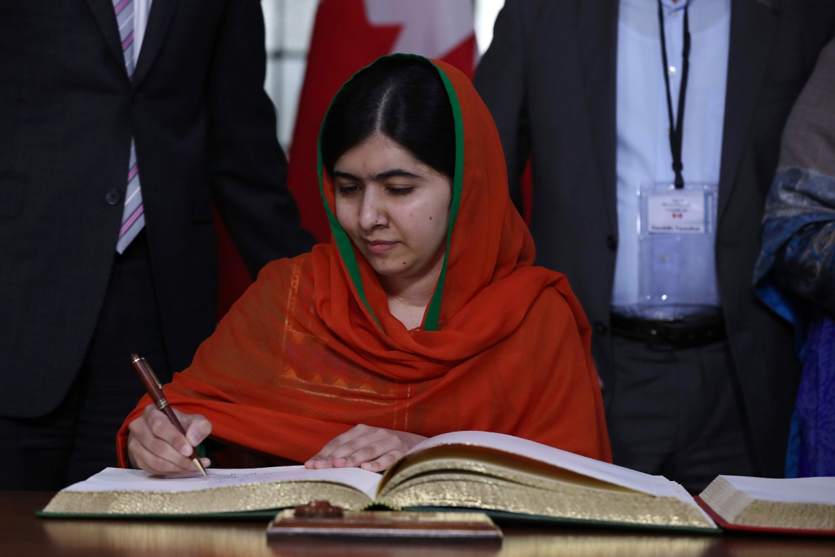 Malala Yousafzai signs a guest book at Parliament Hill in Ottawa, Ontario, April 12, 2017. Malala Yousafzai will receive an honorary Canadian citizenship. Nobel Peace laureate Malala Yousafzai becomes only the sixth person to receive honorary Canadian cit