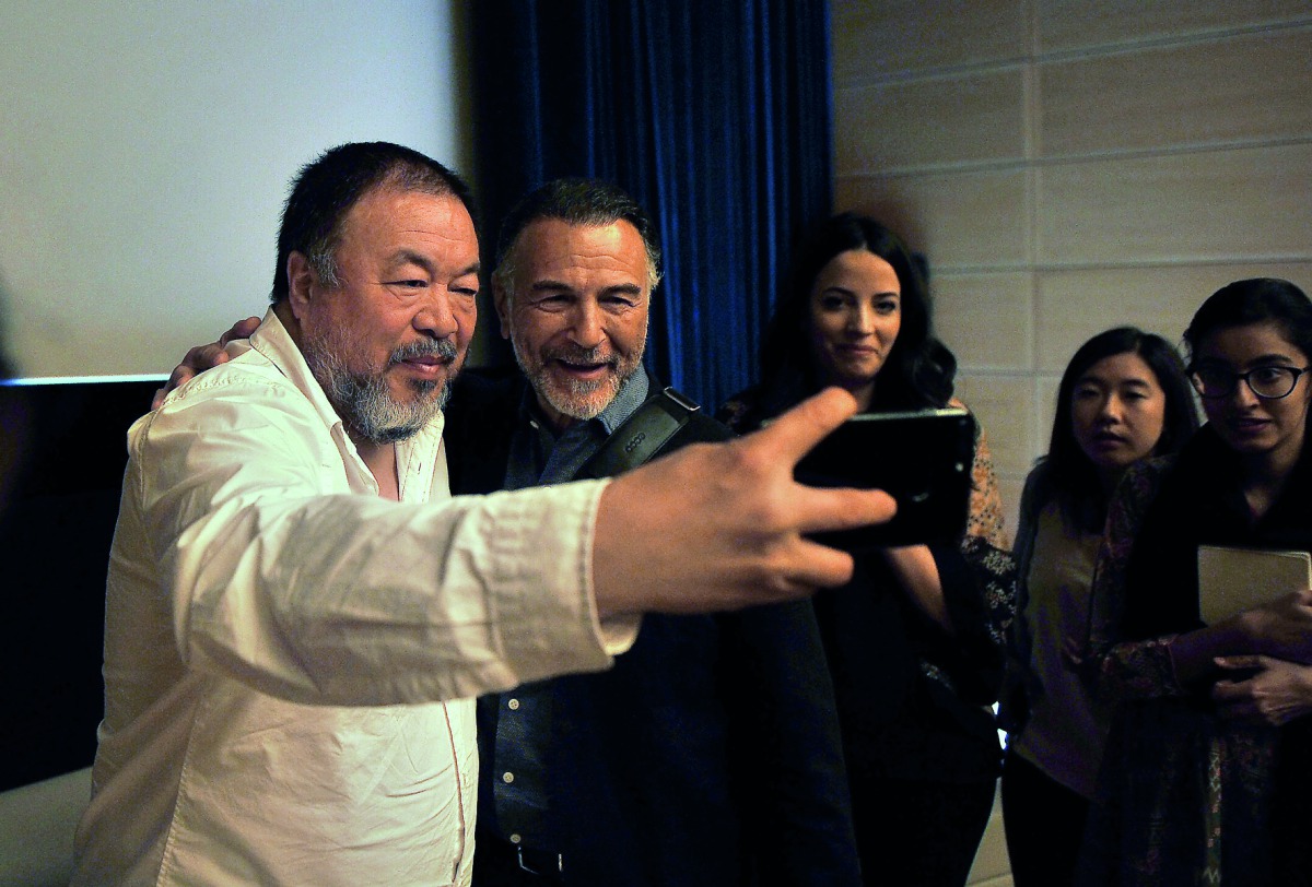 Ai Weiwei taking a selfie with fans and Uli Sigg, a Swiss businessman, diplomat and art collector, at the Museum of Islamic Art. Pic: Baher Amin / The Peninsula
