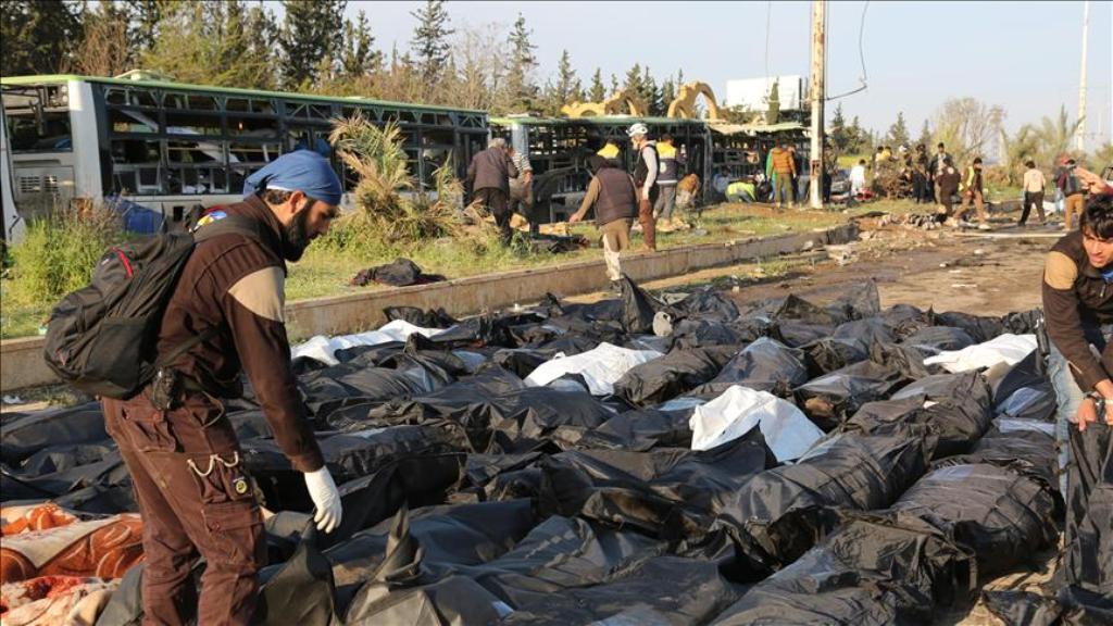 ALEPPO, SYRIA - APRIL 15: Civil defence team members carry dead bodies at the site after bomb-laden vehicle attack held to a convoy, carrying Syrian civilians and opponent forces members those were evacuated from al-Fu'ah and Kefriya districts of Idlib, a