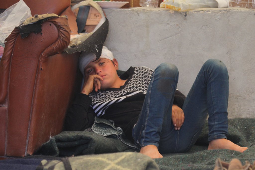 A boy, who was injured during a bomb blast on a crowded Syrian bus convoy outside Aleppo on Saturday, rests inside a tent connected to Bab al-Hawa hospital, near the Syrian-Turkish border, Syria April 18, 2017. REUTERS/Ammar Abdullah