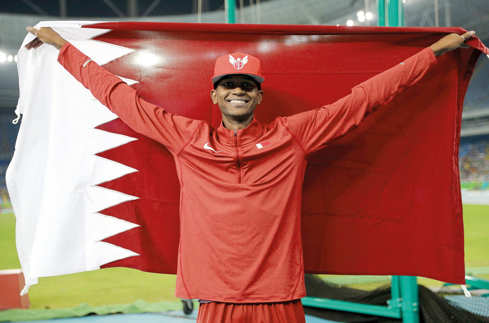 Mutaz Barshim with Qatar flag after winning the silver medal in the high jump event at the Rio Olympic Games in this August 2016 file picture.