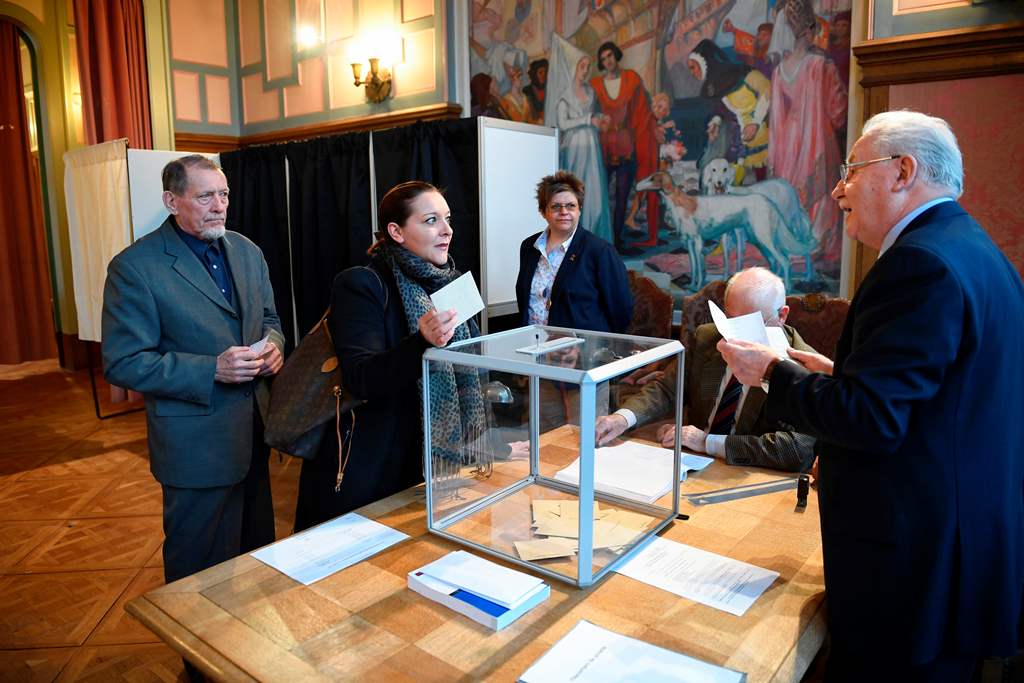 People cast their ballots at a polling station in Le Touquet, northern France, on April 23, 2017, during the first round of the Presidential elections. / AFP / Eric FEFERBERG
