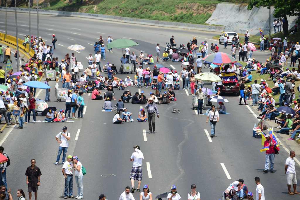 Venezuelan opposition activists block organize a sit-in to block the Francisco Fajardo motorway in Caracas, on April 24, 2017.  AFP / RONALDO SCHEMIDT
