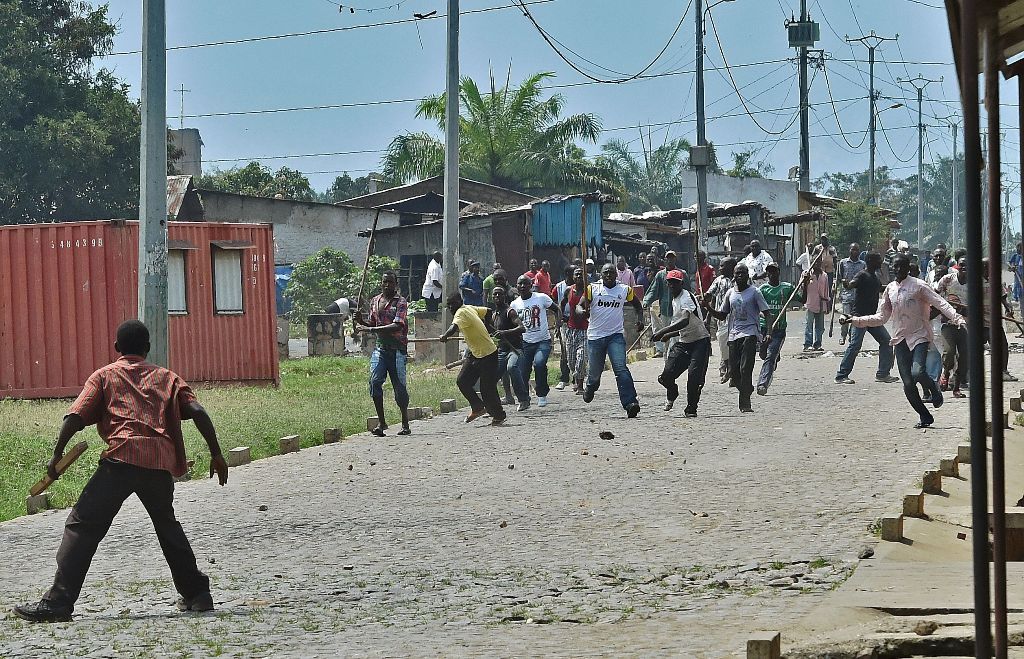 (FILES) This file photo taken on May 25, 2015 in the Kinama neighborhood of Bujumbura on May 25, 2015 shows a protestor opposed to the Burundian President's third term confronting members of the Imbonerakure, the youth wing of the ruling party, armed with